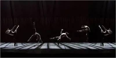 Dancers on a stage with dramatic lighting